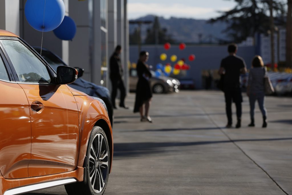 A group of people at a car dealership shopping for a new car