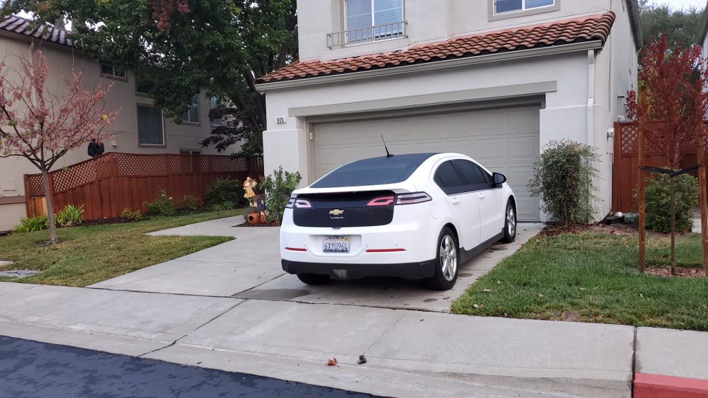 Chevrolet Volt electric car parked on the driveway of a suburban home.