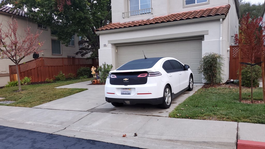 Chevrolet Volt electric car parked on the driveway of a suburban home.