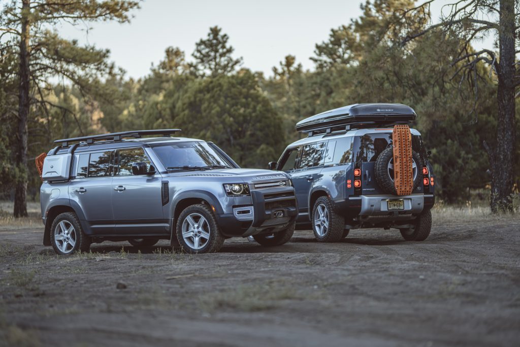 two 2021 Land Rover defenders parked in the dirt. These are the best midsize luxury SUV