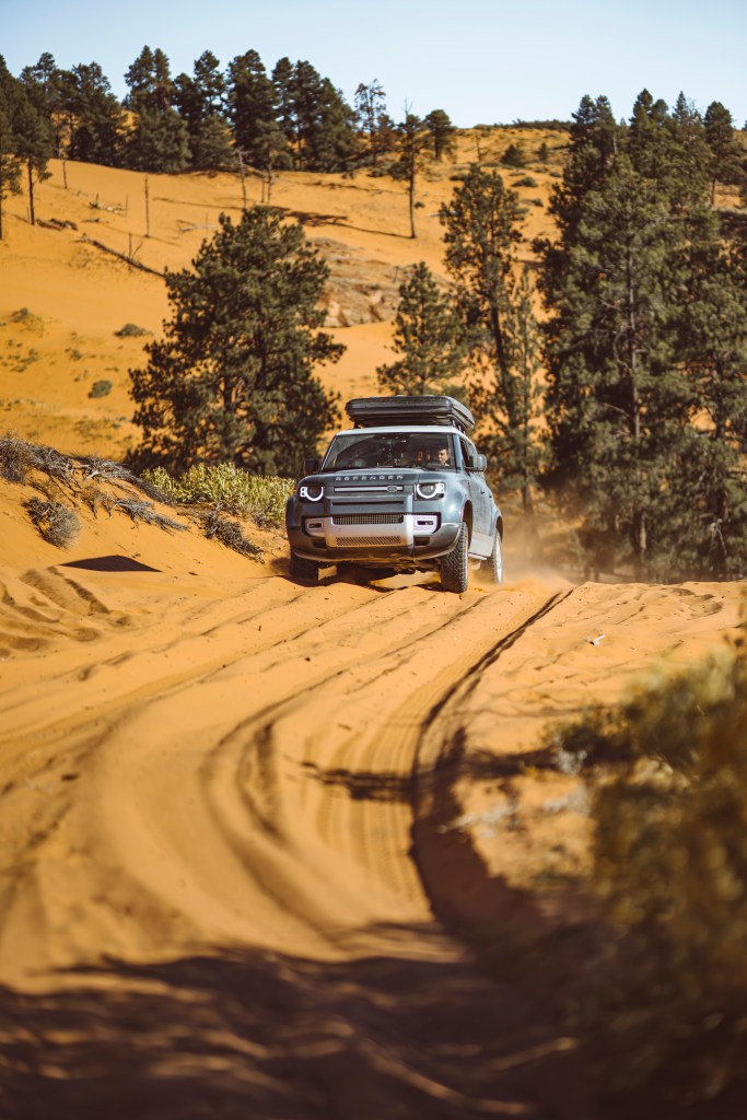 Land Rover defender driving through the sand