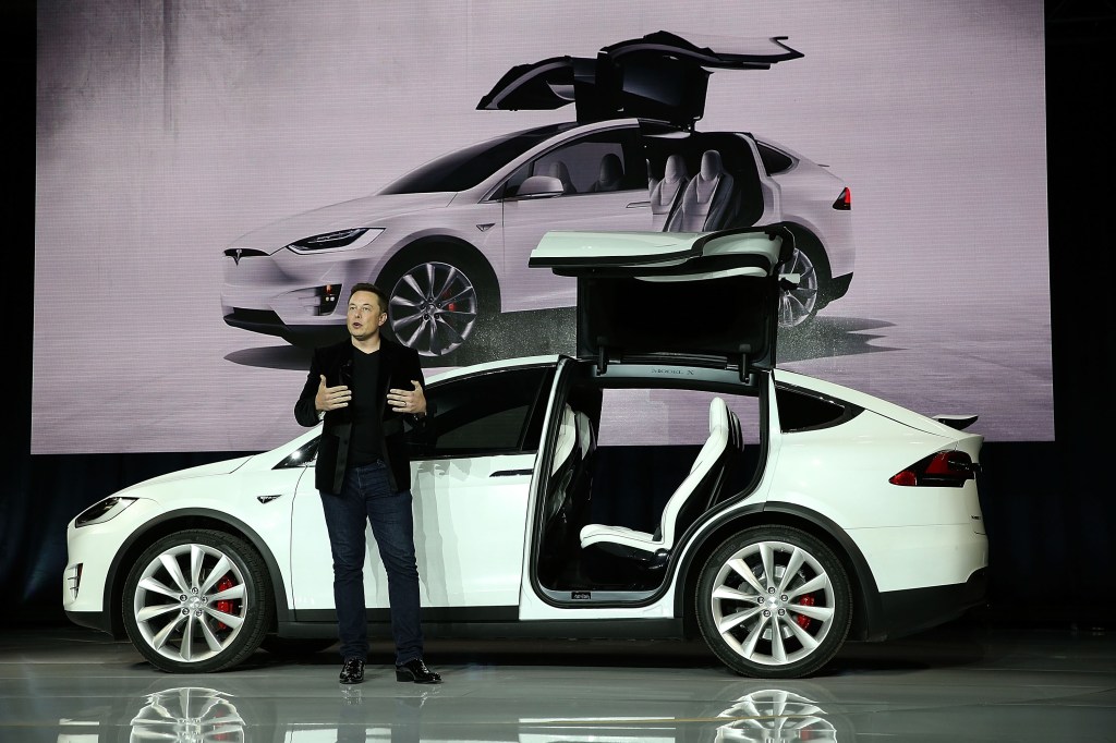 Tesla CEO Elon Musk stands outside of a Tesla Model X.