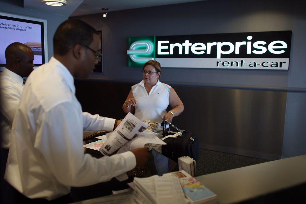 A customer rents a car at an Enterprise rental counter. 