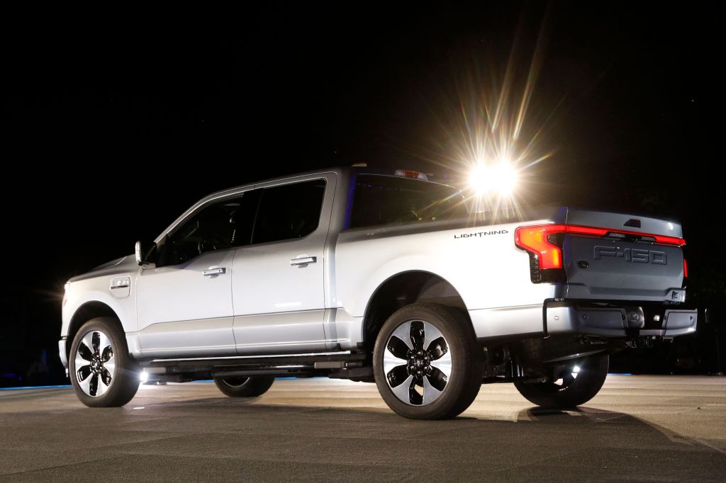 A Ford F-150 Lightning is parked outside at night. 