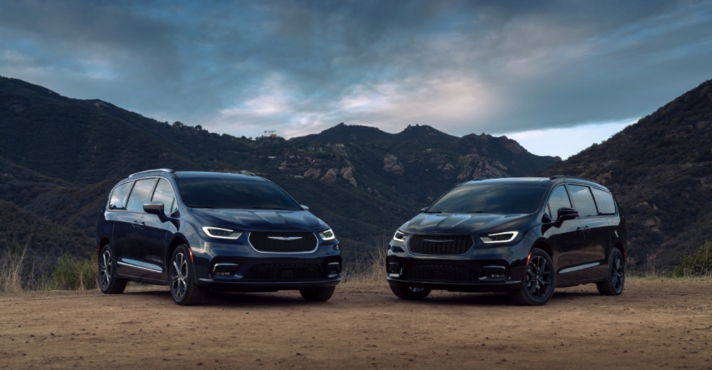 two 2021 Chrysler Pacifica models parked in the dirt in front of mountains 