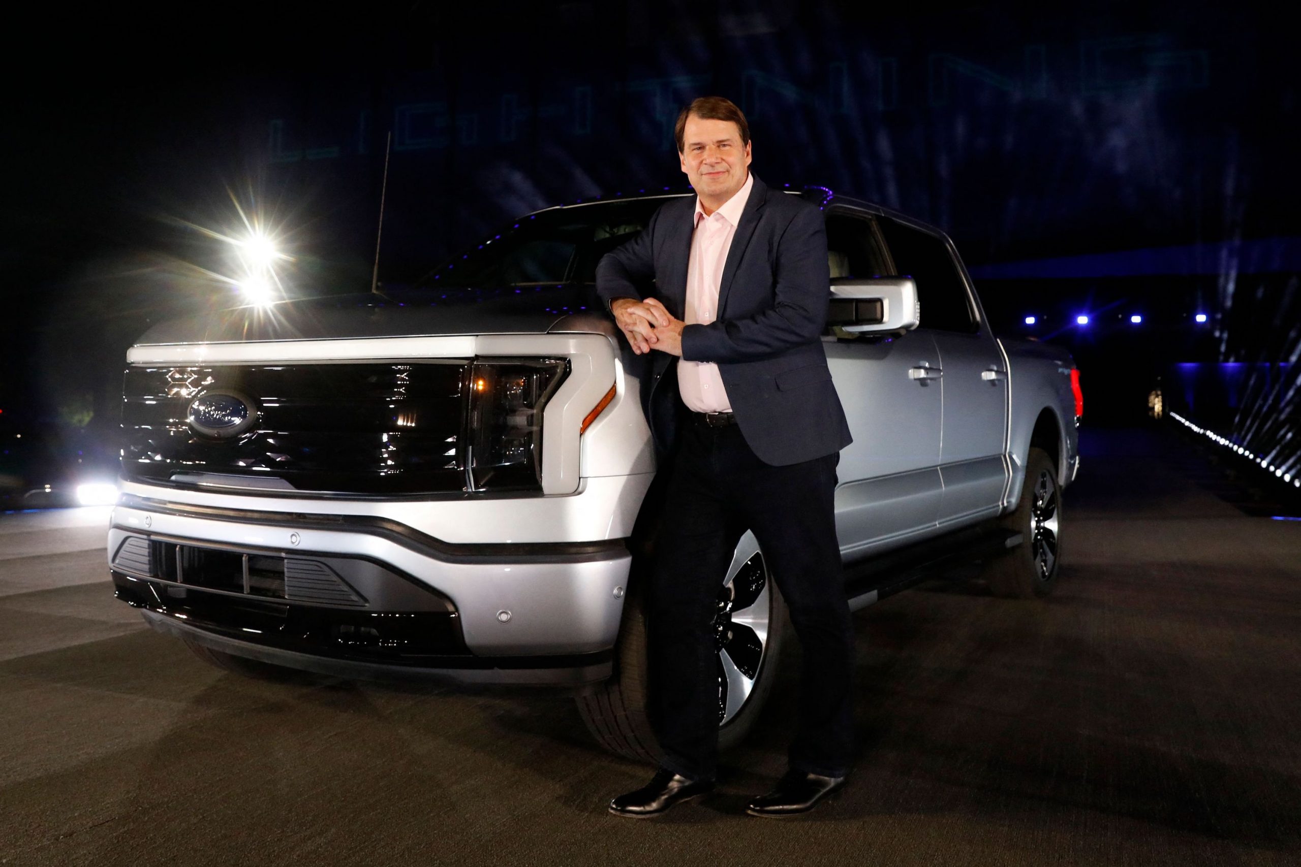 Ford Motor Company's chief executive officer Jim Farley poses next to the newly unveiled electric F-150 Lightning outside of their headquarters in Dearborn, Michigan