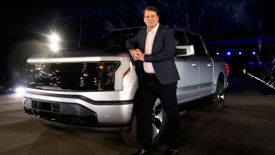 Ford Motor Company's chief executive officer Jim Farley poses next to the newly unveiled electric F-150 Lightning outside of their headquarters in Dearborn, Michigan