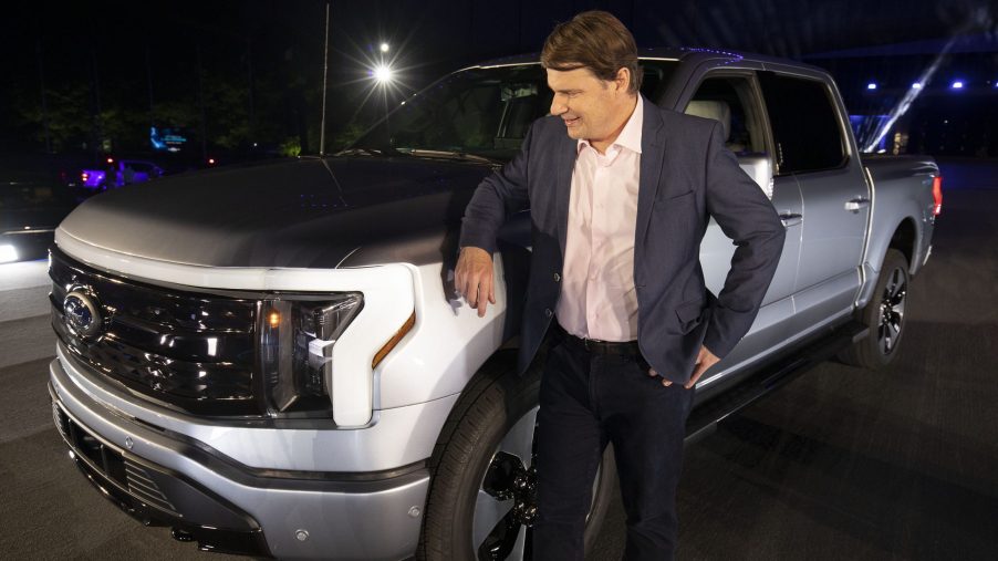 Jim Farley, CEO of Ford Motor Company, poses with the new all-electric silver F-150 Lightning performance truck at its reveal at Ford World Headquarters