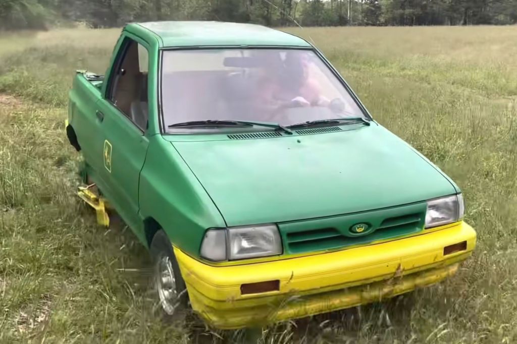 A green and yellow Ford Festiva compact car modified into a lawnmower