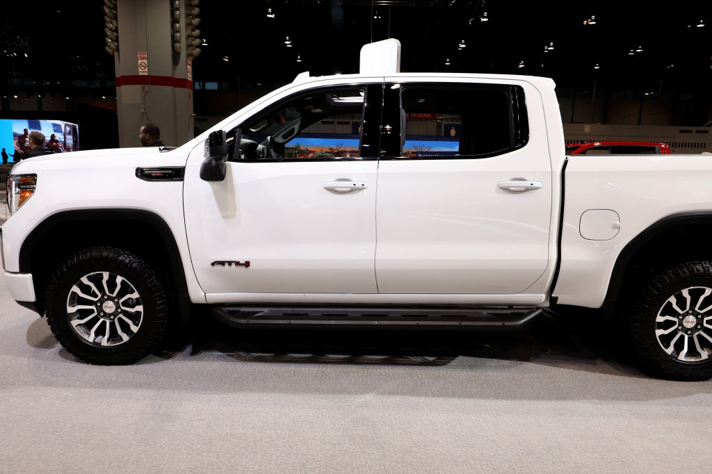 A white GMC Sierra parked in a showroom.