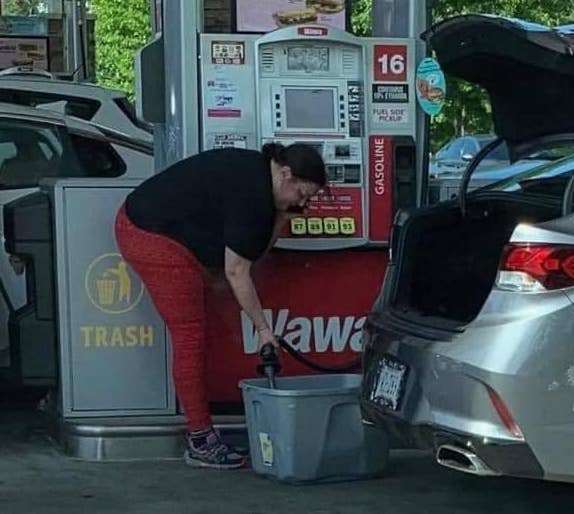 woman filling up plastic storage container with gas