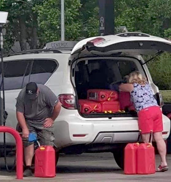 hoarding gasoline a couple are filling 5 gallon cans of gas