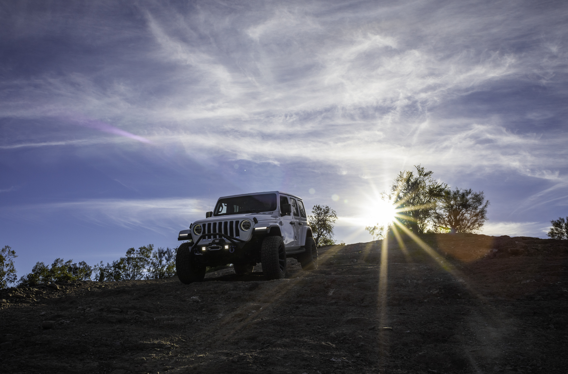 The Jeep Wrangler is the SUV with the best resale value partly because of the off-road prowess demonstrated by this white Wrangler climbing down a rocky hill