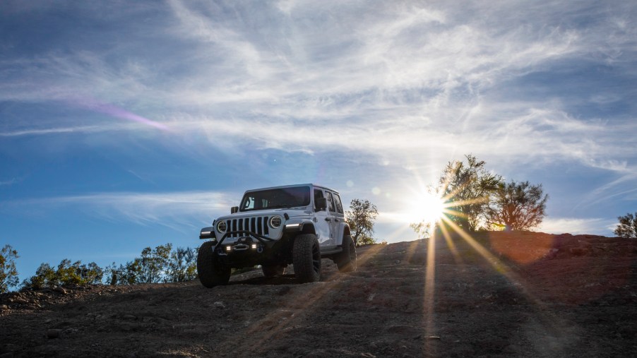 The Jeep Wrangler is the SUV with the best resale value partly because of the off-road prowess demonstrated by this white Wrangler climbing down a rocky hill