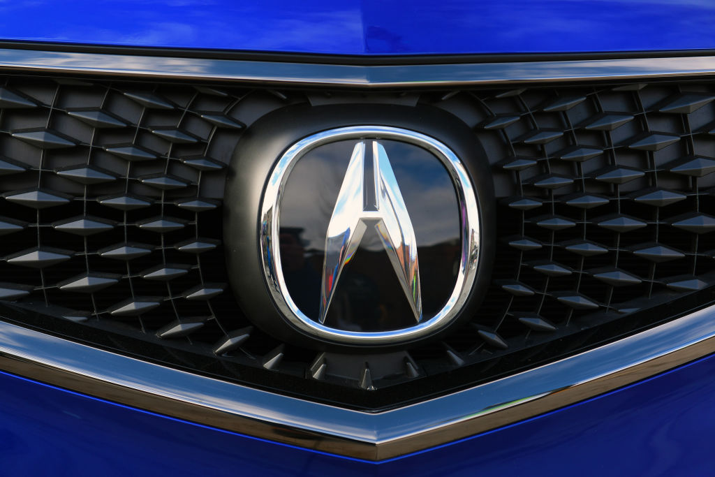 The Acura badge sitting on the grille of a blue TLX
