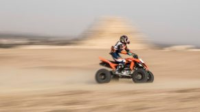 an ATV rider on a quad riding fast in the desert
