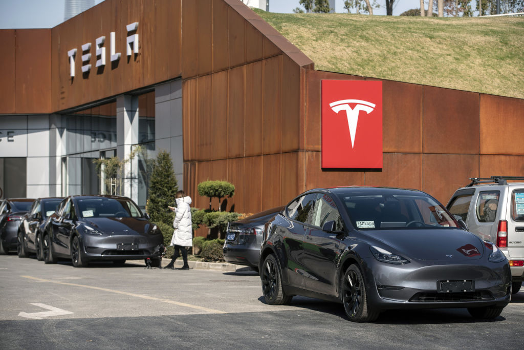 A grey Tesla Model Y sits outside a showroom