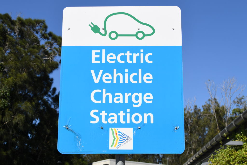 A sign stating "EV charge station" on a blue background