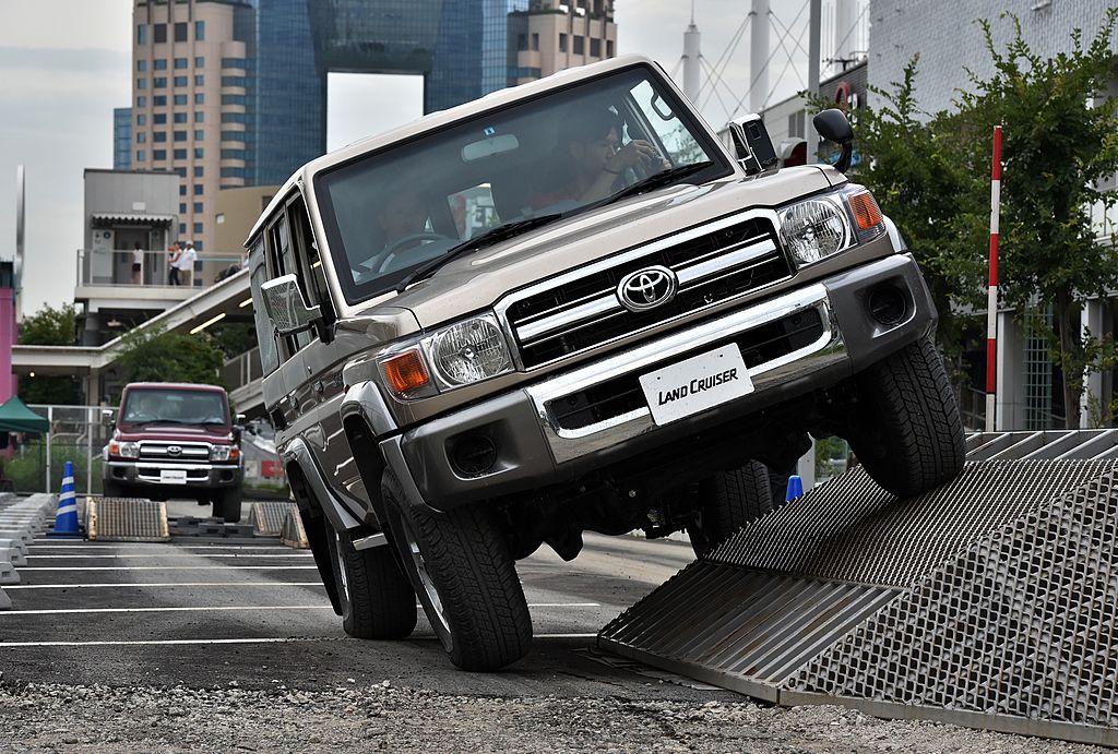a 70 Series Land Cruiser generation SUV in a demo driving over an obstacle