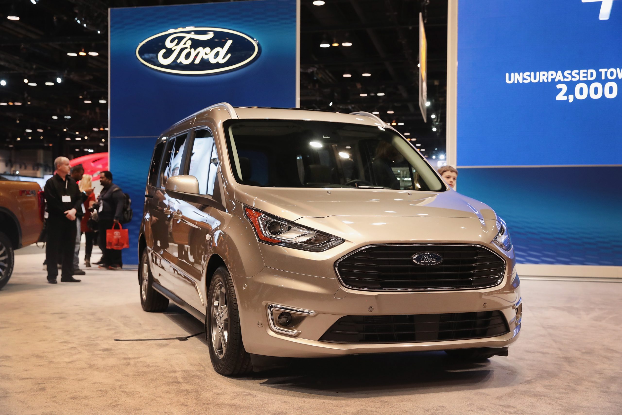 a silver ford transit connect at an auto show