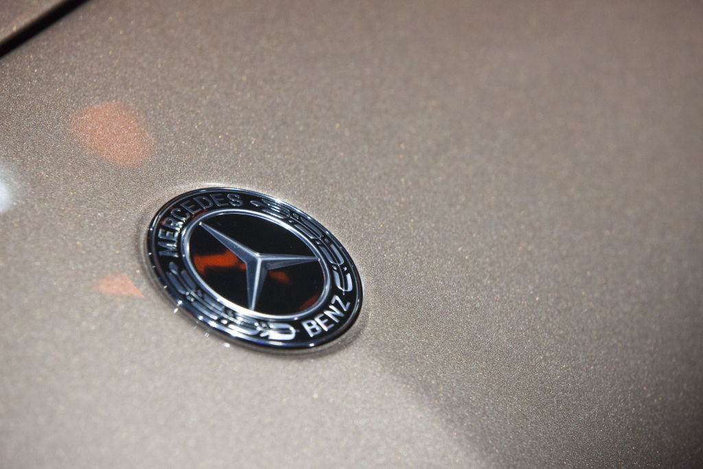 The Mercedes-Benz badge photographed on the nose of a car.