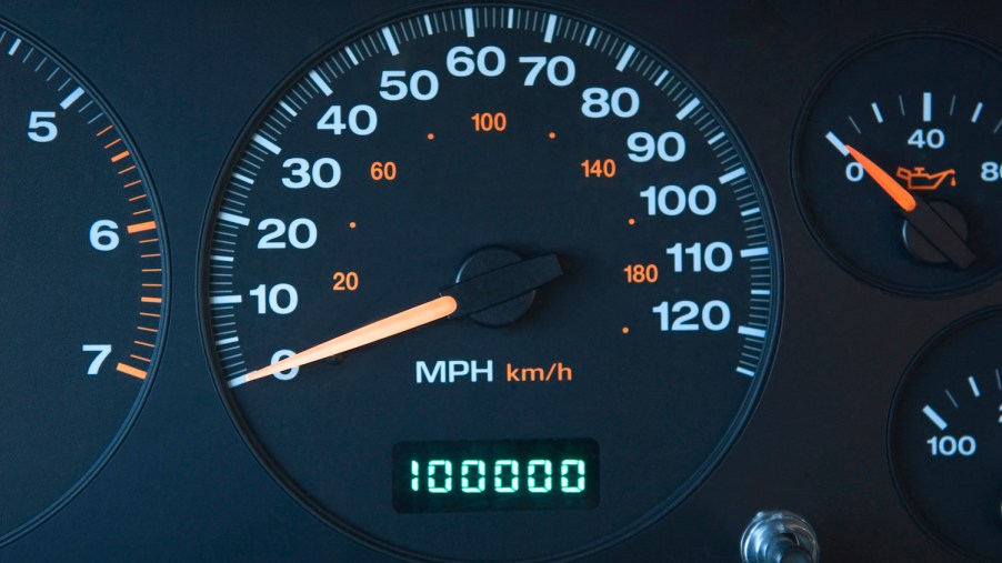 A high-mileage car shown with 100,000 miles on the odometer