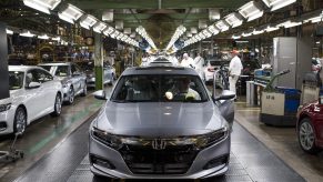 An employee prepares to drive a silver 2018 Honda Accord vehicle off the assembly line at the Honda of America Manufacturing Inc. Marysville Auto Plant
