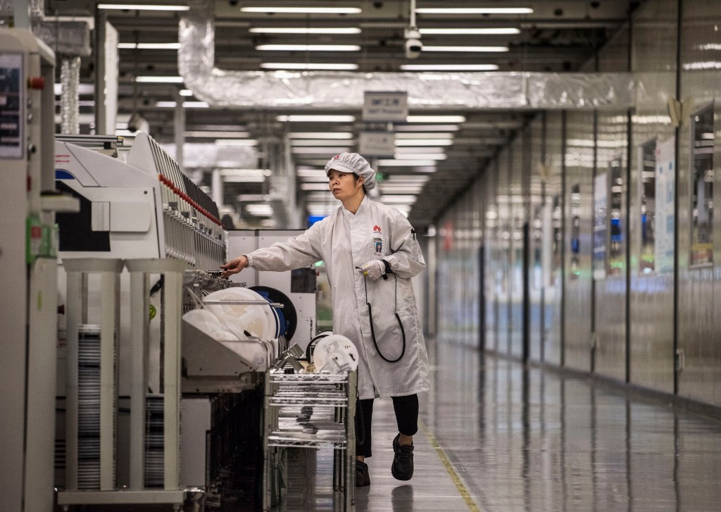 A woman packs up cellphones in a Huawei production plant
