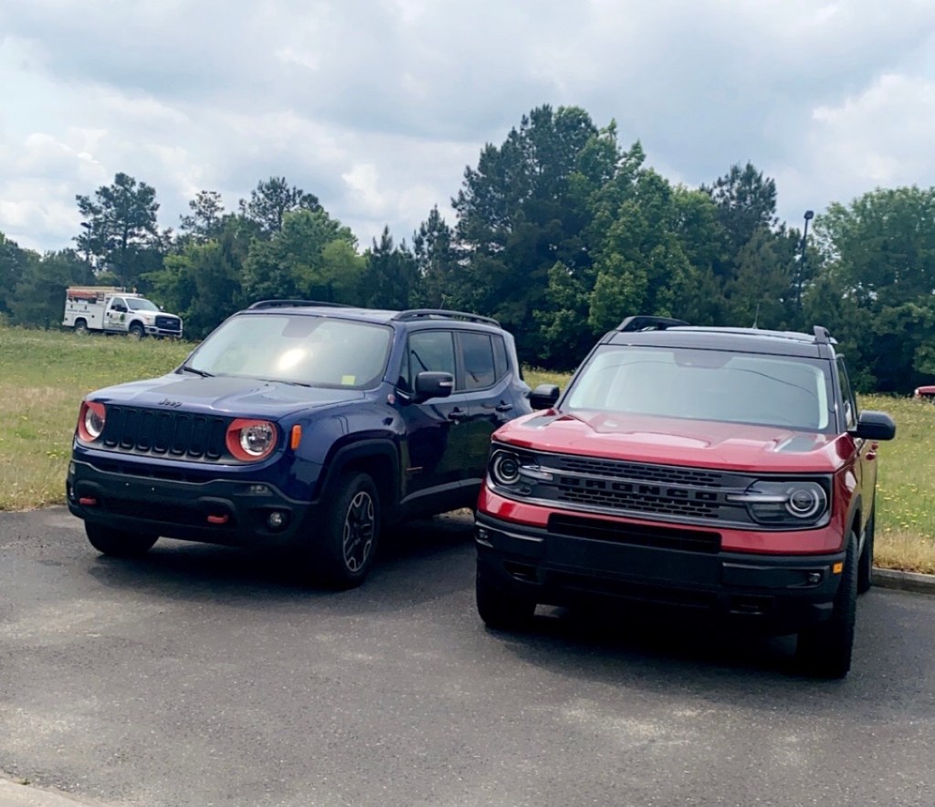 A blue 2016 Jeep Renegade Trailhawk model parked beside a red 2021 Ford Bronco Sport First Edition model