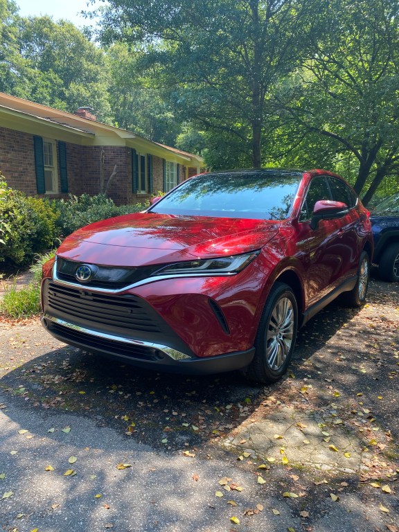 A red 2021 Toyota Venza parked near a home 