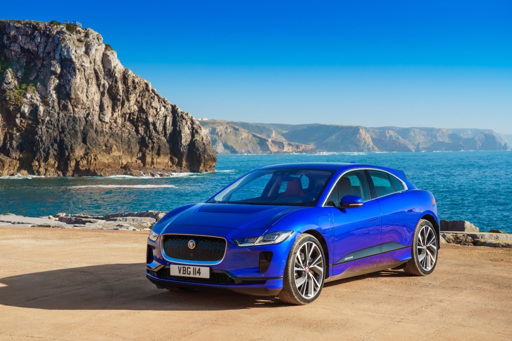 A blue Jaguar I-PACE parked by water