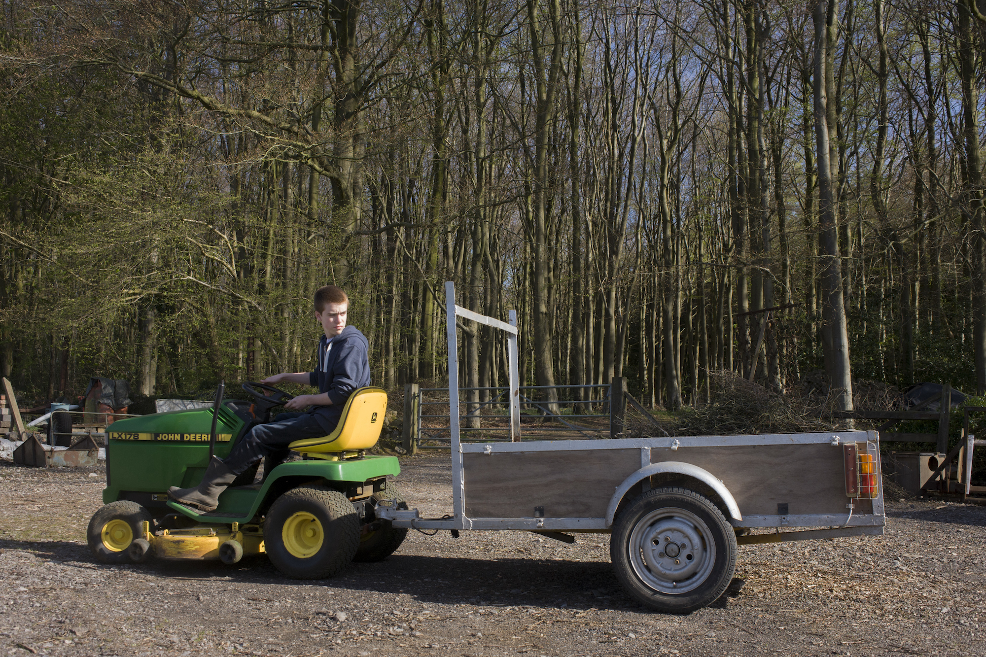 A 15-year-old reverses a small tractor on a family farm