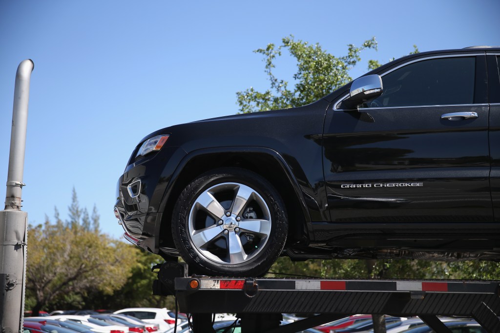 A Jeep Grand Cherokee on a transport truck to its destination.