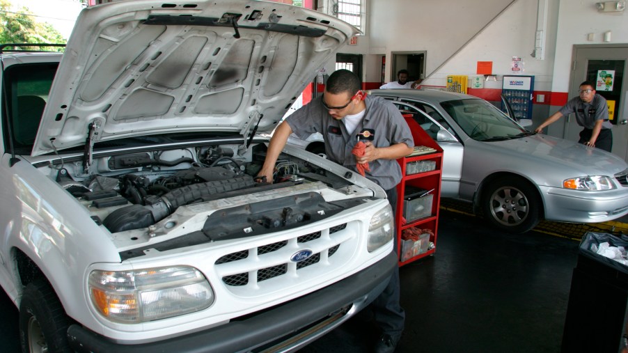 mechanic performs car maintenance on a Ford Explorer