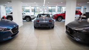 Automobiles manufactured by Mazda Motor Corp., including a gray Mazda MX-5 Miata, centre, in the showroom of a dealership