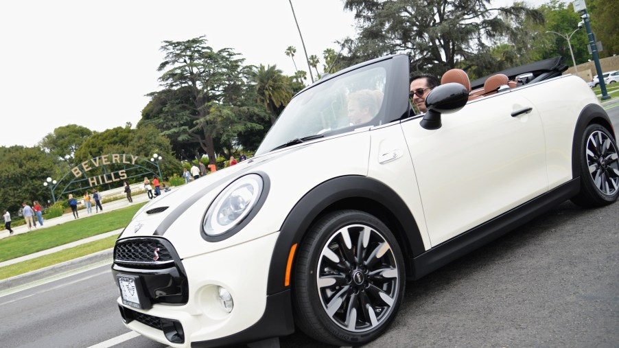 A white Mini Cooper convertible drives past Beverly Gardens Park at the 2019 BritWeek Car Rally on April 28, 2019, in Beverly Hills, California