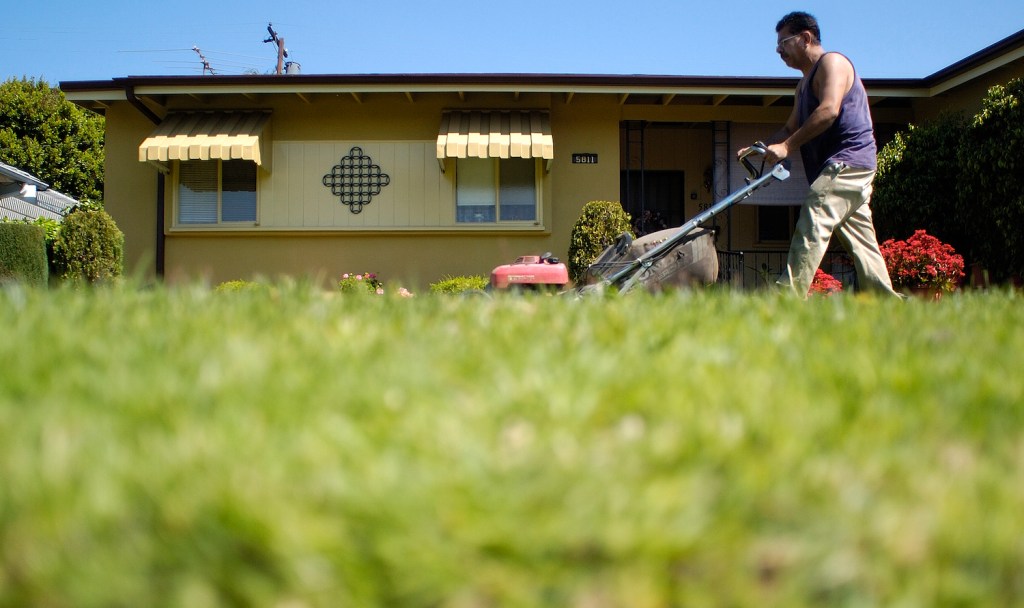 A man mowing a small yard.