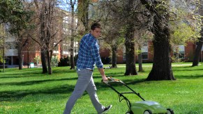 A man mowing the lawn with an electric lawn mower