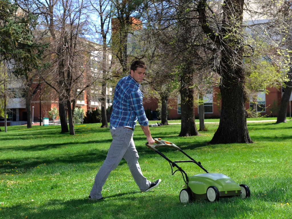 A man mowing the lawn with an electric lawn mower