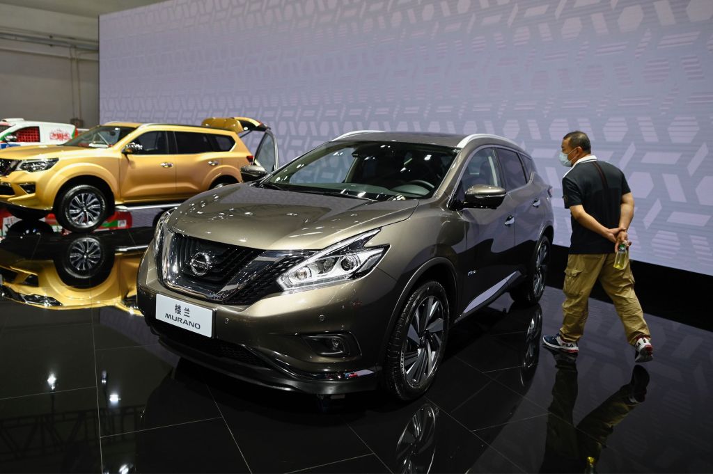 A man looks at a gray Nissan Murano car displayed at the Beijing Auto Show in Beijing
