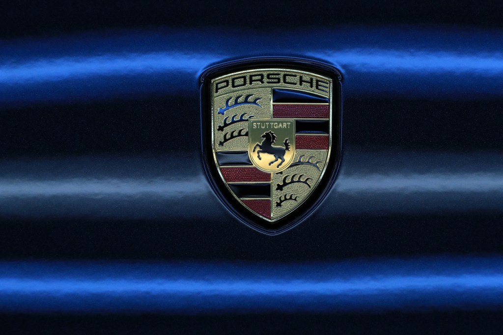 Classic Porsche logo against a black and blue background