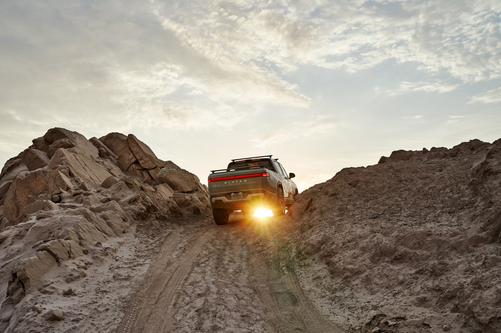 Rivian R1T cresting a ridge at sunup
