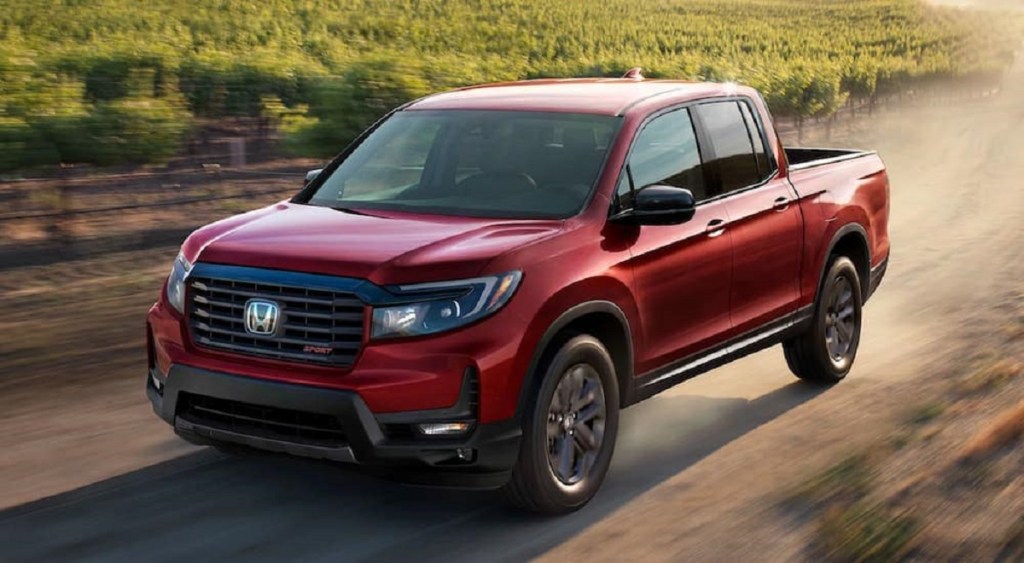 A red 2021 Honda Ridgeline races down a dirt road. Consumer Reports ratings make the Ridgeline a great choice.