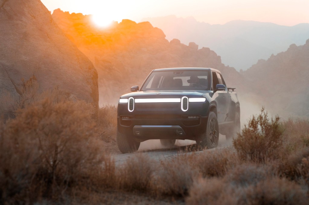Rivian electric truck parked in a hazy desert. The Rivian R1T will be many people's first EV. 