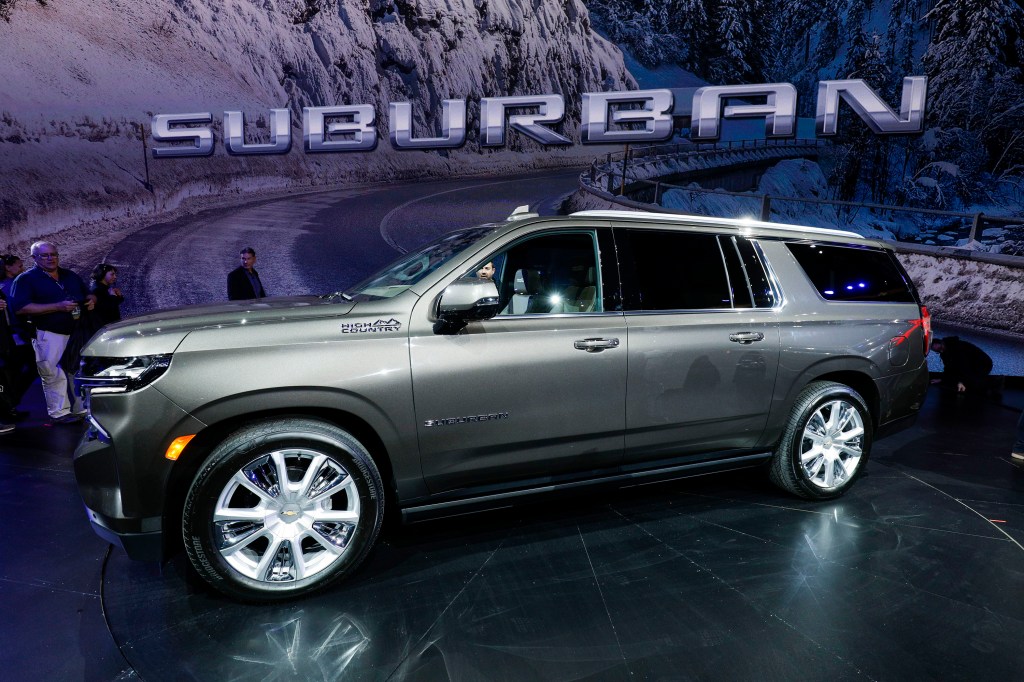 A 2021 Chevy Suburban is revealed at a car show. The Suburban is very similar to the GMC Yukon.