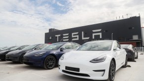 A lineup of Tesla Model 3s, one of the best luxury EVs according to Truecar