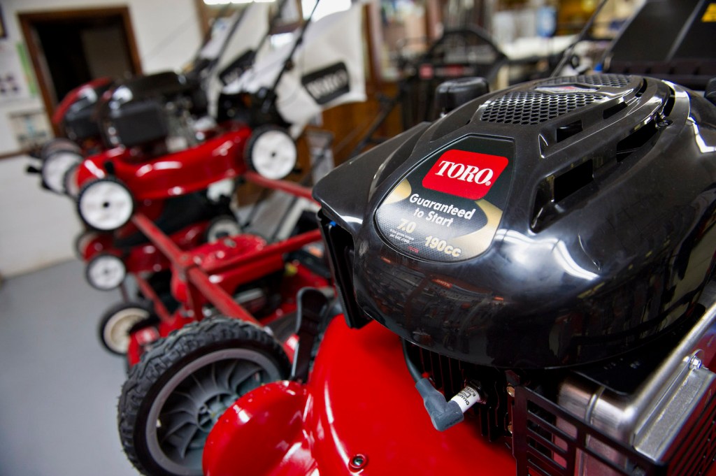 A lineup of red Toro lawn mowers, the Toro Timemaster 21199 is among the best gas push mowers