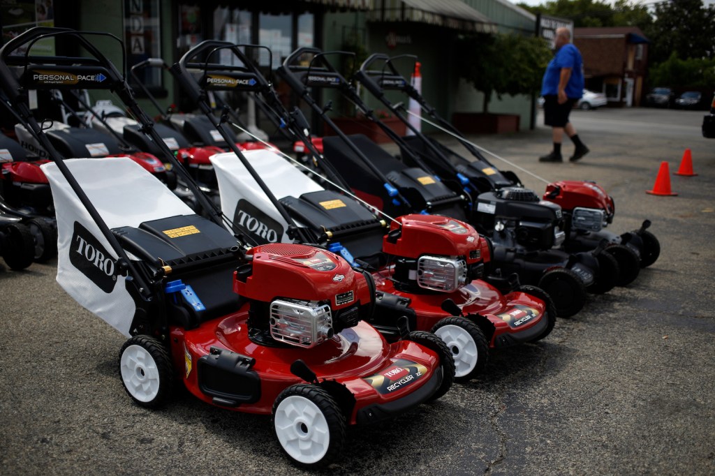 A lineup of red Toro push lawn mowers, a brand recommended by Consumer Reports for mowing small yards