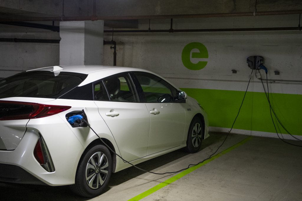 A white Toyota Prius is seen connected to a electric vehicle charging station in a Washington, D.C., parking garage