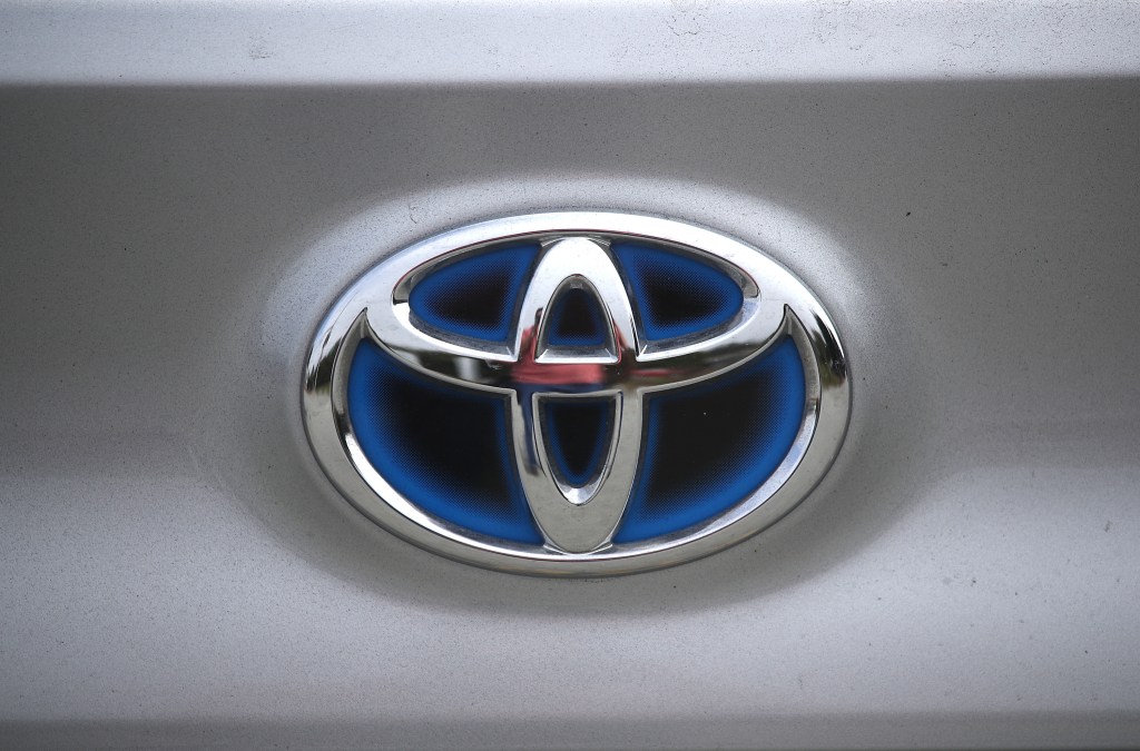 A blue and chrome Toyota emblem on a silver vehicle